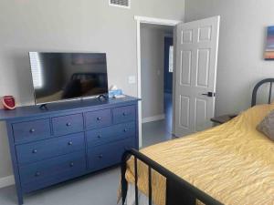 een slaapkamer met een blauwe dressoir en een televisie. bij Desert Ranch Home 3 Bedroom + Equine Facility in Vail