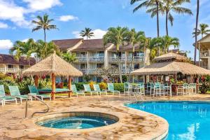 a resort with a pool and chairs and palm trees at Islander Resort Oceanfront # 149 in Kapaa