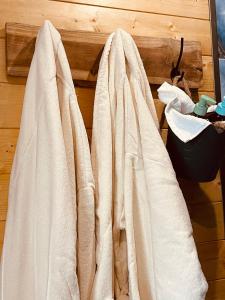 a group of white robes hanging on a wall at Cense AB in Saint-Amand-les-Eaux