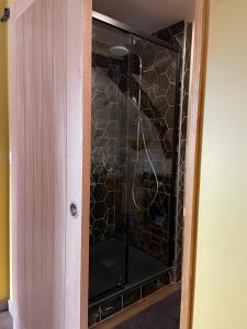 a glass cabinet with a glass door in a room at Espace bien être Jacuzzi in Saint-Amand-les-Eaux