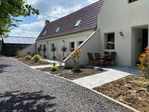 a house with a patio with a table and chairs at Love Room in Saint-Amand-les-Eaux