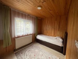 Habitación pequeña con cama y ventana en Cay Suite, en Uzungöl