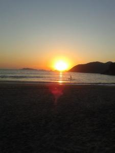 una puesta de sol en una playa con puesta de sol en Shambhala Quarto Ecológico Beira Mar entre Paraty e Ubatuba en Ubatuba