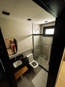 ein kleines Bad mit einem WC und einer Dusche in der Unterkunft Apartamento Vila do Lago in Mata de Sao Joao