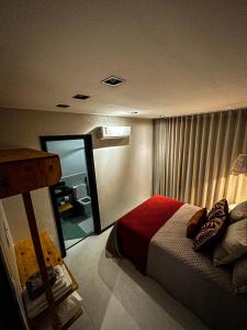 ein Hotelzimmer mit einem Bett und einem Spiegel in der Unterkunft Apartamento Vila do Lago in Mata de Sao Joao
