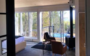 uma sala de estar com vista para uma piscina em Charlevoix expérience thermale en pleine nature - Suites Nature Charlevoix - Suite #2 em Les Éboulements