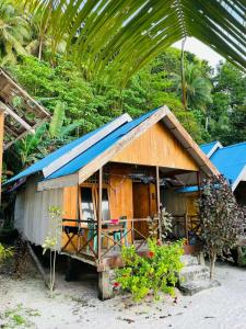a small wooden house with a blue roof at Pondok Lestari Kadidiri in Batudaka