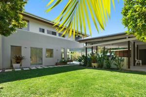 a house with a lawn in front of it at Witta Circle - Walk to Hastings St & Noosa Beach in Noosa Heads