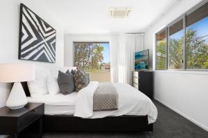 a bedroom with a bed and a large window at Witta Circle - Walk to Hastings St & Noosa Beach in Noosa Heads +27 photos
