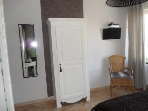 a white door in a room with a chair at Manoir du Brugnobois in Surques