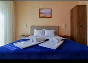 a bedroom with a blue bed with two towels on it at Apartments Hillside in Ulcinj