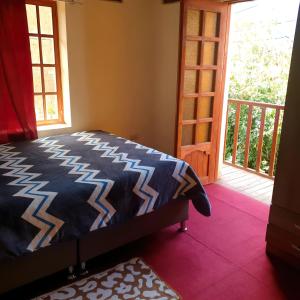 1 dormitorio con 1 cama y puerta a un balcón en Hermosa casa de campo, en Maras