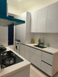 喬治市的住宿－2BR Beacon Executive Suites @ Georgetown，厨房配有白色橱柜和炉灶烤箱。