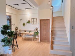 a hallway with stairs in a home with a table at Gardenstay in Luodong