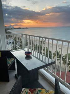 a table on a balcony with a view of the beach at Ocean Front Condo in Isla Verde! in San Juan