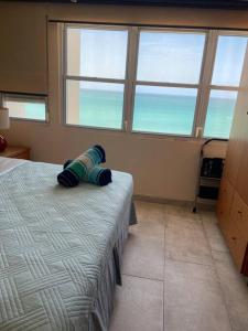 un dormitorio con una cama con un animal de peluche en Ocean Front Condo in Isla Verde!, en San Juan