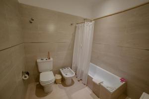 a bathroom with a toilet and a bath tub at La Boya Departamentos in La Paz +45 photos