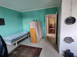 a room with blue walls and a bed and a hallway at Haus Ayen in Hannover
