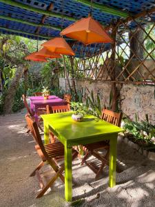 a green table and two chairs with umbrellas at Hostel Candelaria in Valladolid