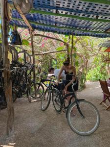 a man is sitting on a bike under a canopy at Hostel Candelaria in Valladolid