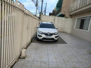 un coche aparcado en un estacionamiento junto a una valla en Estúdio central PG1 prox Paladium en Ponta Grossa