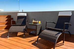 2 Stühle und ein Tisch auf einer Terrasse in der Unterkunft Mérit Montevideo Apart & Suites in Montevideo