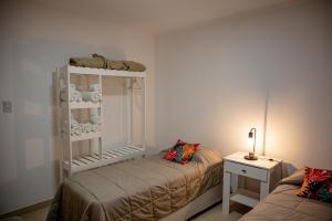 Habitación con 2 camas y mesa con lámpara. en La Boya Departamentos en La Paz
