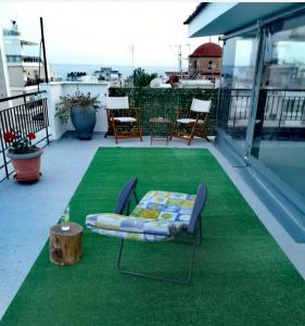 a patio with a bed and a table and chairs at Domi's Rooftop Apartment in Thessaloniki
