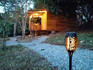 una cabaña de madera con una luz de la calle delante de ella en La cabaña de Aurora en Comala