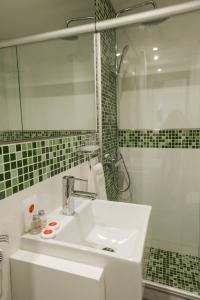 biała łazienka z umywalką i prysznicem w obiekcie Mérit Montevideo Apart & Suites w mieście Montevideo