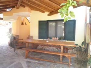 a wooden bench sitting outside of a house at B&b Su Acu in Dorgali