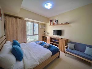 1 dormitorio con 1 cama grande y 1 sofá azul en Highview IT Park, en Cebú