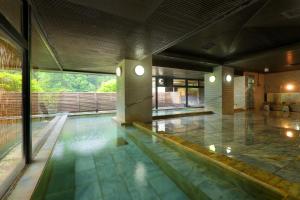 a swimming pool in a building with a swimming pool at Hotel Sunshine Kinugawa in Nikko