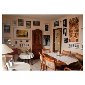 a living room with a table and chairs and pictures on the walls at Haus am See in Horn-Bad Meinberg