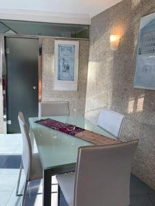 a dining room with a green table and white chairs at Luminoso y centrico apartamento en Plaza de España posición estratégica in Pontevedra