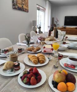 una mesa con platos de comida y fruta. en Embaixada da Vila, en Cascais