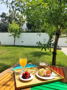 a table with a plate of food and a glass of orange juice at Embaixada da Vila in Cascais