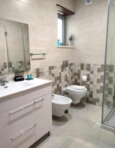 a bathroom with a toilet and a sink and mirror at Embaixada da Vila in Cascais