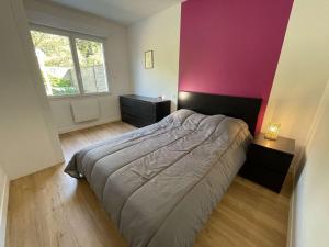 a bedroom with a bed and a pink wall at Maison rénovée 5 pièces, jardin clos, à 2 pas de l'océan, pour 10 personnes - Saint-Jean-de-Monts - FR-1-224C-231 in Saint-Jean-de-Monts