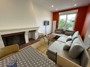a living room with a couch and a fireplace at Maison rénovée 5 pièces, jardin clos, à 2 pas de l'océan, pour 10 personnes - Saint-Jean-de-Monts - FR-1-224C-231 in Saint-Jean-de-Monts