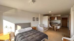 1 dormitorio con 1 cama grande y cocina en machado apartamentos moron en Morón