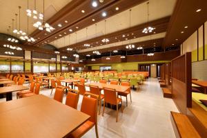 日光鬼怒川日光酒店(Hotel Sunshine Kinugawa)的用餐室配有桌椅