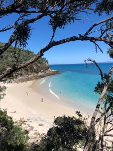 a beach with people swimming in the ocean at Great Keppel Island Hideaway in Great Keppel