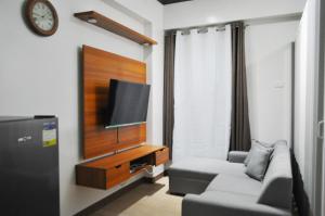 a living room with a couch and a flat screen tv at Apparate Staycation in Hope Residences - Trece, Cavite, Philippines in Cavite