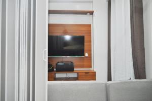 a living room with a tv on a wall at Apparate Staycation in Hope Residences - Trece, Cavite, Philippines in Cavite