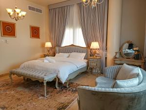a bedroom with a bed and a couch and a chair at HOOUD Apartments in Khor Fakkan