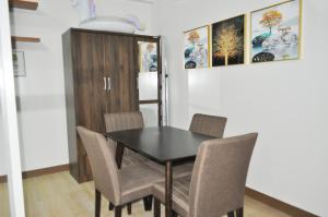 a dining room with a black table and chairs at Apparate Condotel Staycation in Cavite