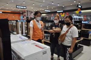 Drei Leute tragen Gesichtsmasken in einem Laden. in der Unterkunft Apparate Condotel Staycation in Cavite