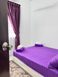 a purple bed in a room with a window at Raina Muslim Homestay Perlis in Arau