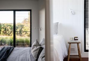 1 dormitorio con cama y ventana grande en Carinya Byron Bay, en Hayters Hill